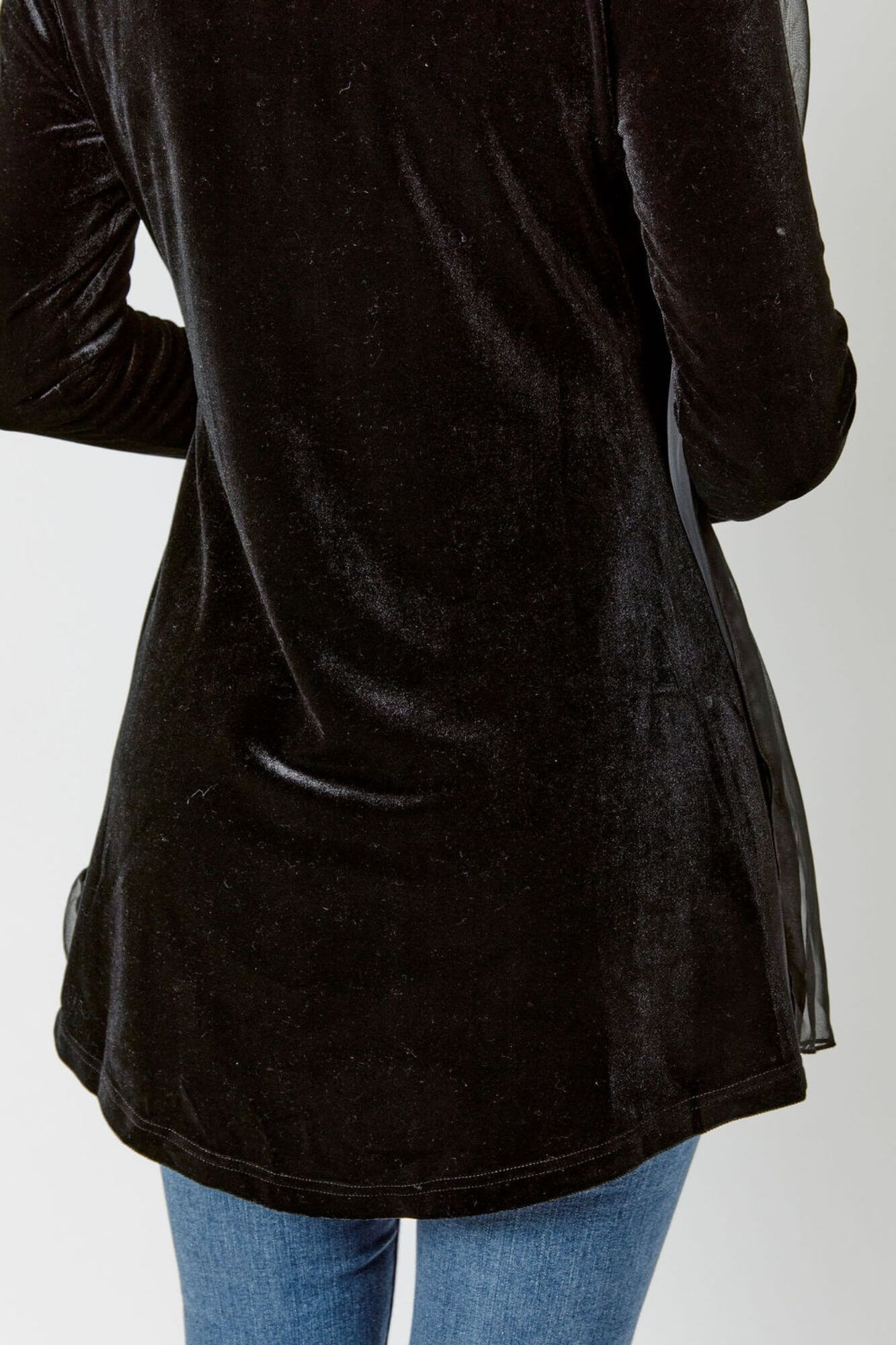 Black long-sleeve top worn by a person on a white background